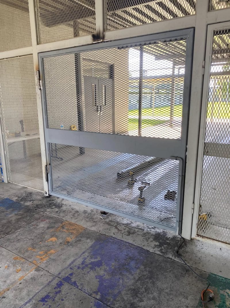 Mesh security cage wall with a hinged door