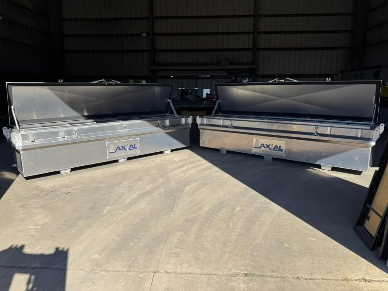 Two aluminum toolboxes with lids open outside the shop