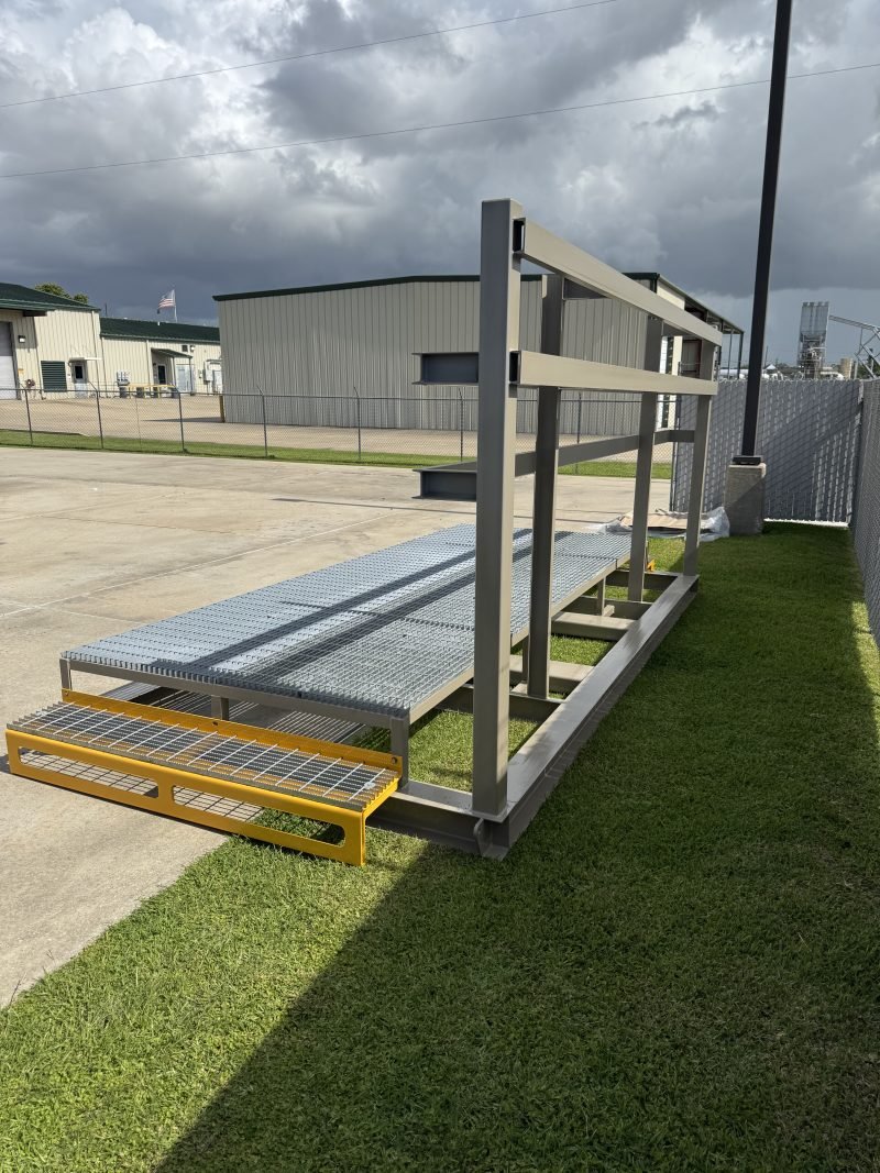 Walkway platform frame with grating and handrail staged on the grass